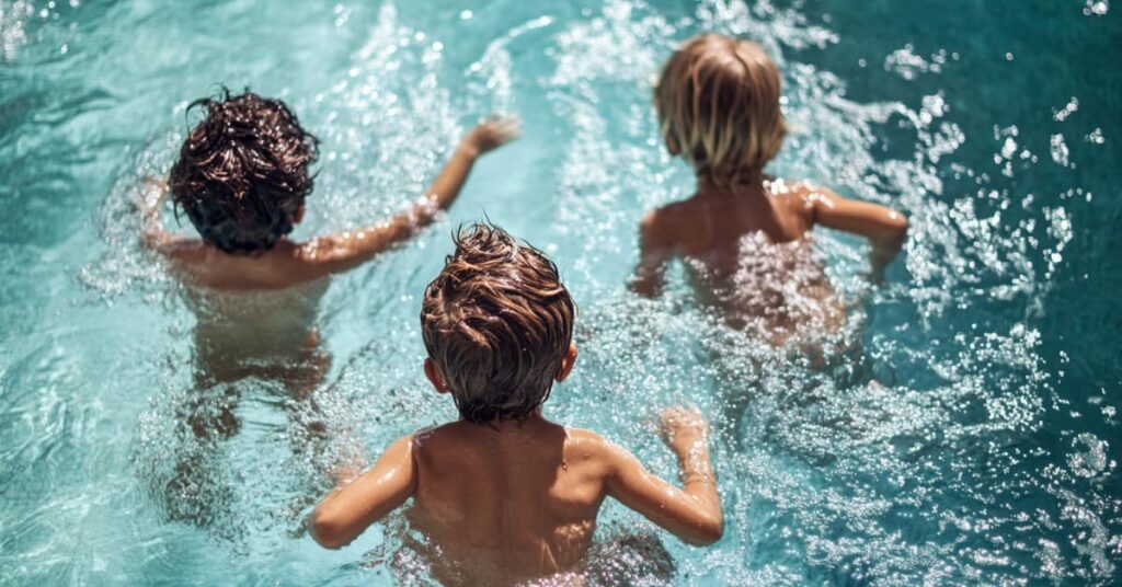 the back of 3 children in pool